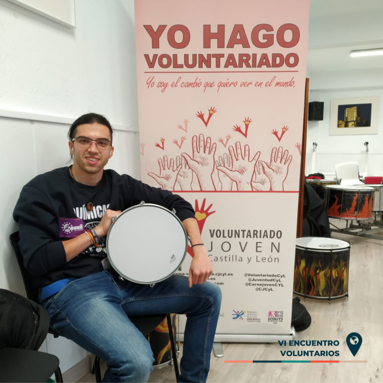 Gonzalo posa con un tambor en la sala de talleres del encuentro de voluntarios